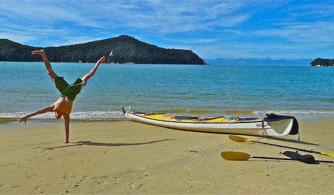 Steve Kamb doing cartwheels on a beach paradise