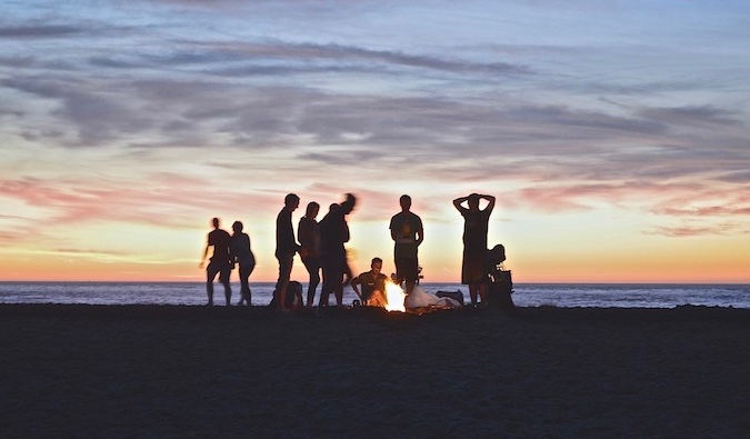 Travelers hanging out on a beach together