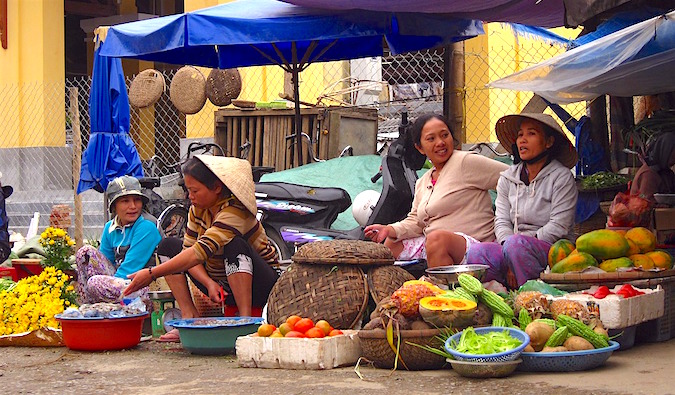 A group of local women at a market stall in Southeast Asia