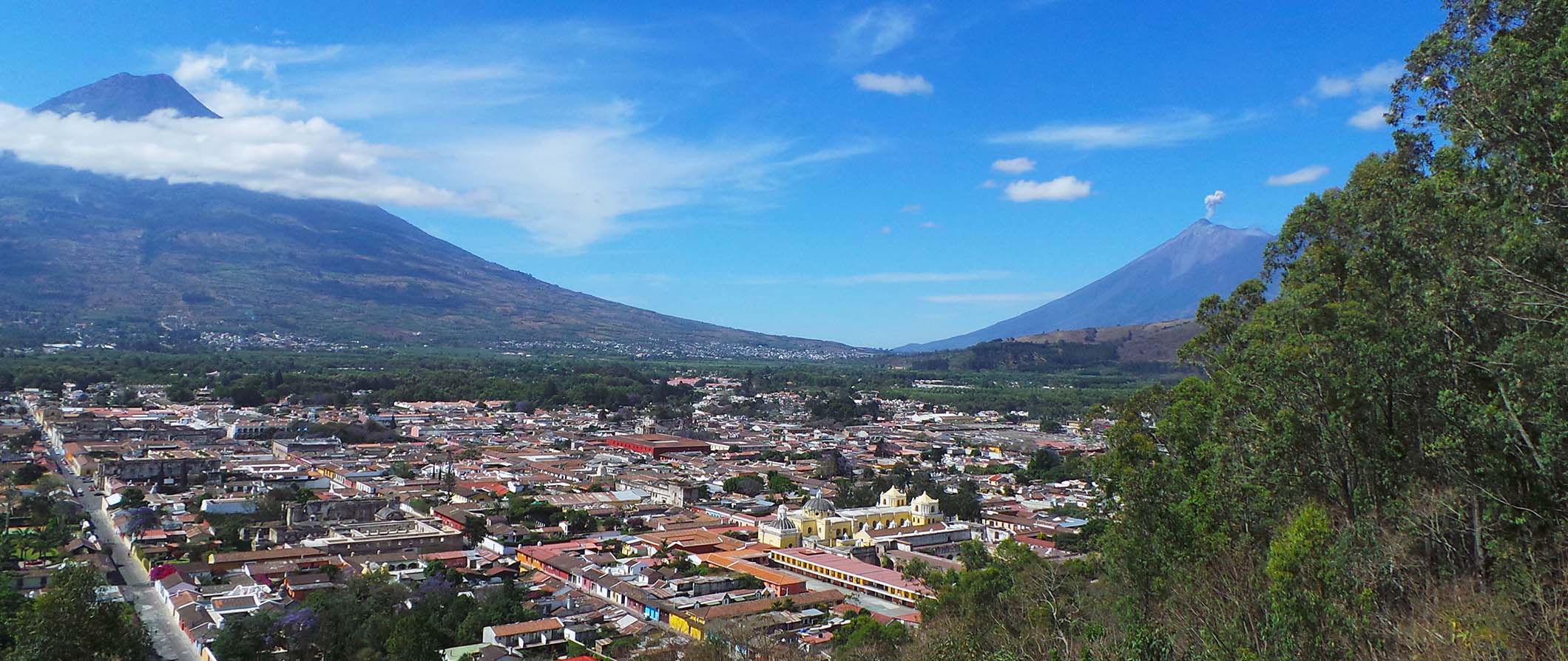 A volcano view in Guatemala with a small town nestled in the valley between the mountains