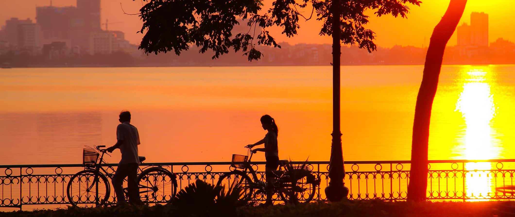 sunset and people on bikes in Hanoi