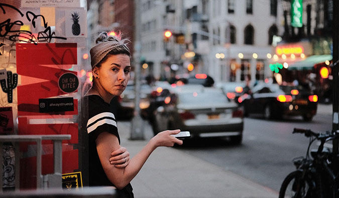 A woman standing alone on a busy street dealing with harassment