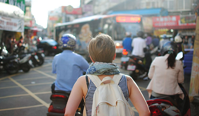 A woman walking down the street in a busy foreign city