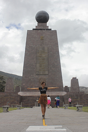 Heather, a solo female traveler, standing on the equator