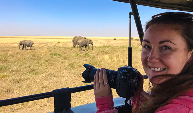 A solo female traveler taking photos on safari in Africa