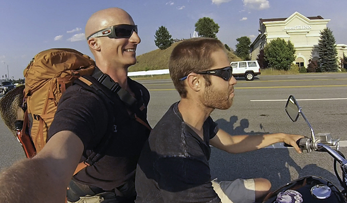 Two guys on a motorcycle, on a motorcycle owner, the other is a hitchhiker in America