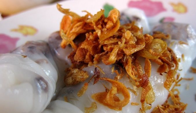 traveling and eating steamed pork and mushroom spring rolls topped with fried garlic in Muang Ngoi, Laos