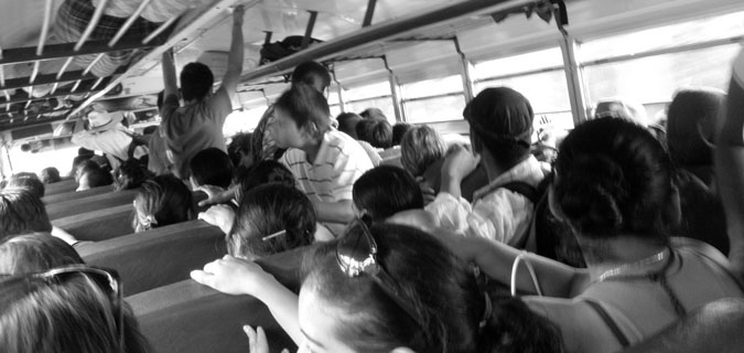 Black and white photo of people on a crowded bus in Africa