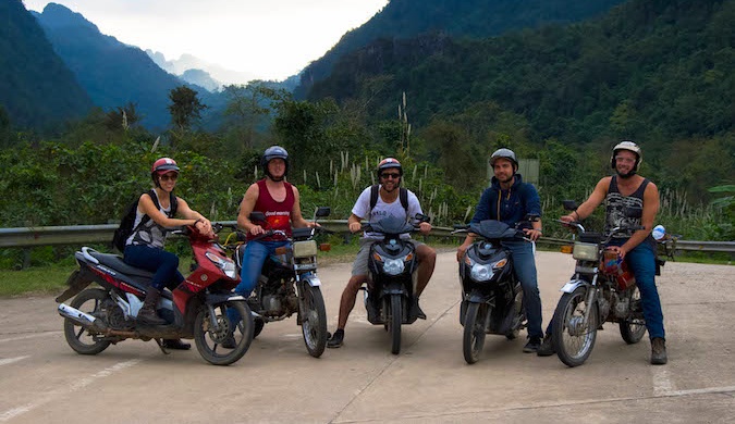 Five people on motorbikes traveling in Southeast Asia