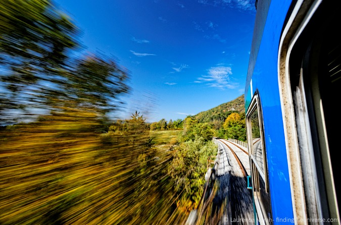 Photo from a fast train passing by a lush landscape