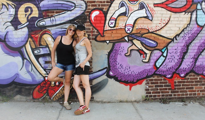 couple leaning against wall with street art