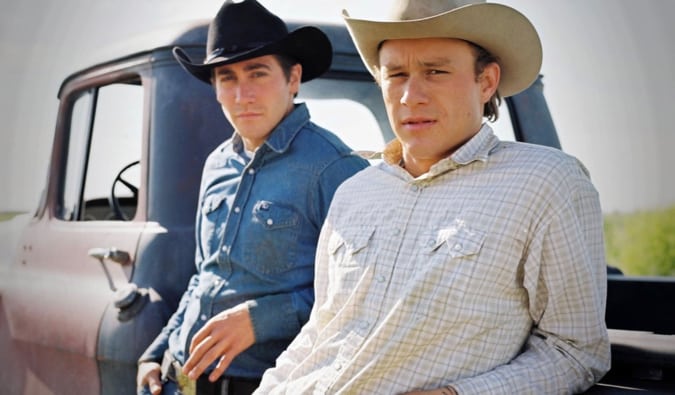 A two main characters from Brokeback Mountain standing beside their truck