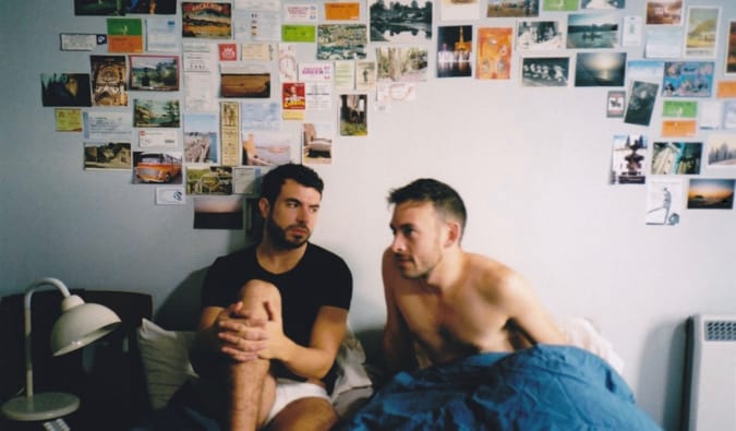 Two men sitting in bed