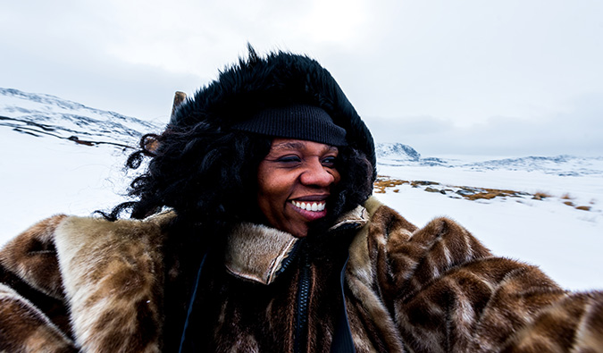 Travel photographer and writer Lola A. Akerstrom posing for a photo in Northern Sweden during the winter