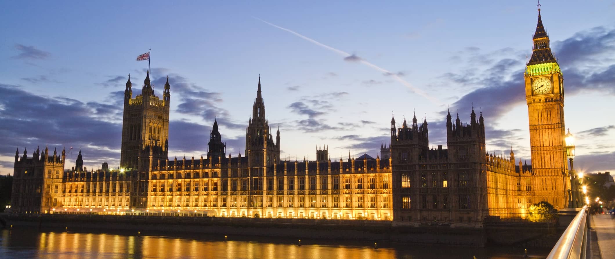 The iconic London Parliament building lit up at night in bustling London, England