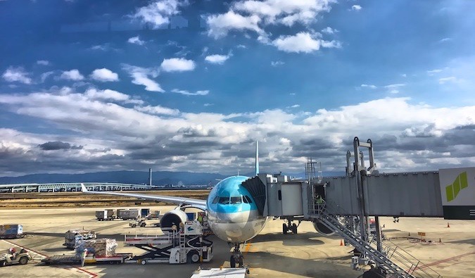 A passenger airplane parked at a gate attached to a loading tunnel