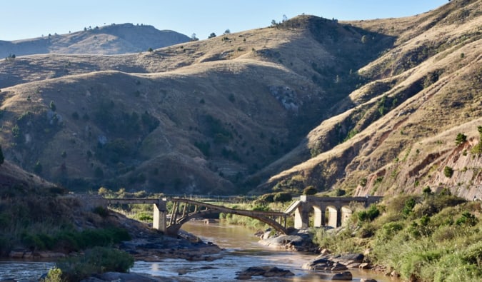 A collapsed bridge spanning a drying river in a valley in Madagascar