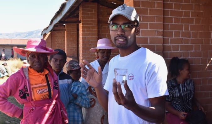 A tour guide with Intrepid Travel giving a talk surrounded by tourists and locals