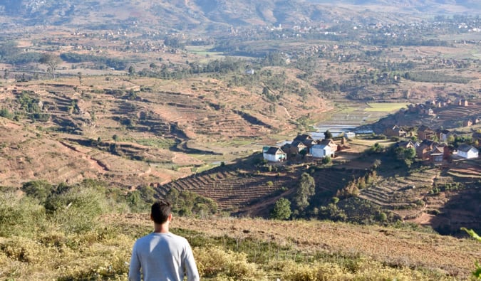 Nomadic Matt standing in an arid valley full of brown fields in MAdagascar