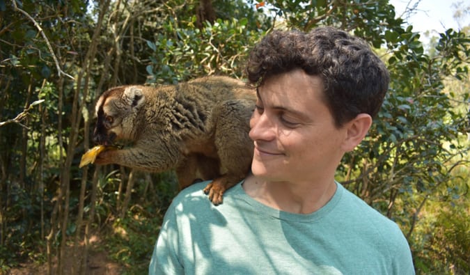 Nomadic Matt with a brown lemur sitting on his shoulder in Madagascar