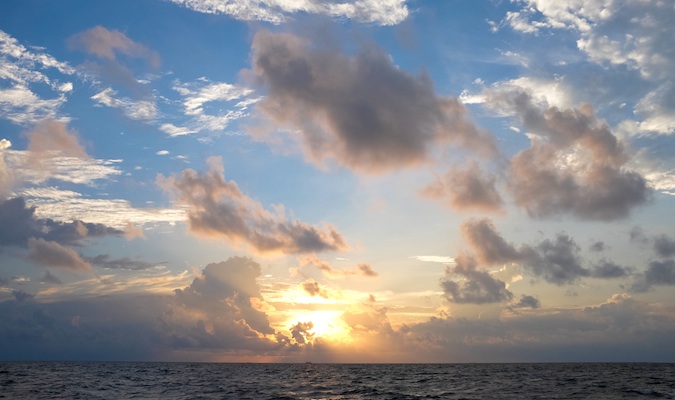 a cloudy sunset over the water in the Maldives