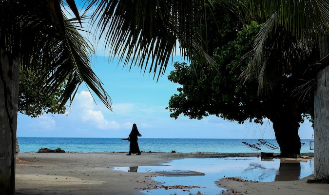 A local Muslim woman walking along the beach in the Maldives