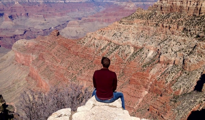 Mark Manson sitting on the edge of the Grand Canyon in the USA