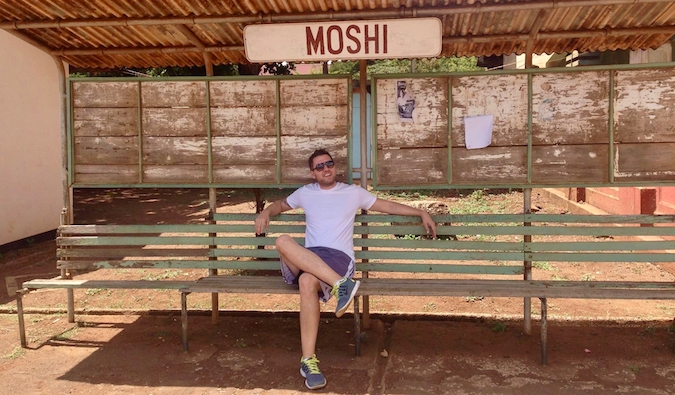 Mark Manson sitting at a bus stop in Moshi, Tanzania