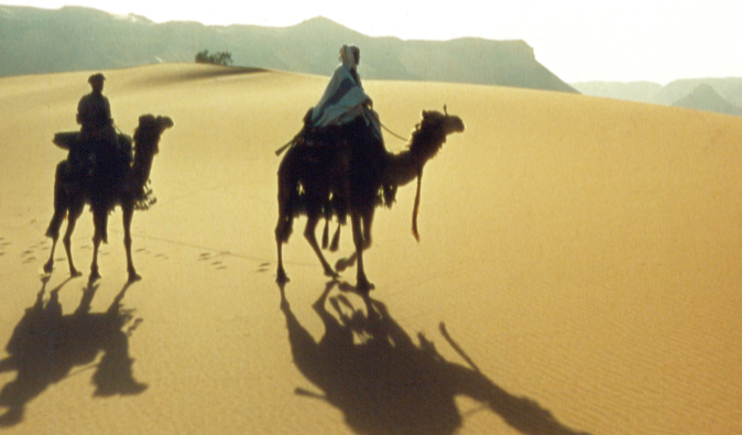 Lawrence of Arabia riding camel back through the desert in this classic film