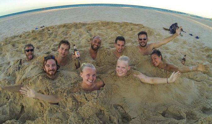 Friends buried up to necks in sand in Mozambique, Africa