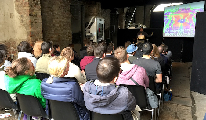 A group of people sitting down listening to a lecture at a conference