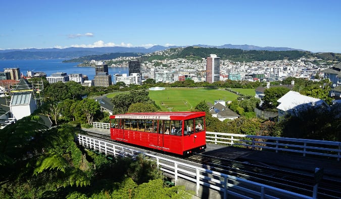 The red cable car ascending its track with the skyline of Wellington, New Zealand in the background