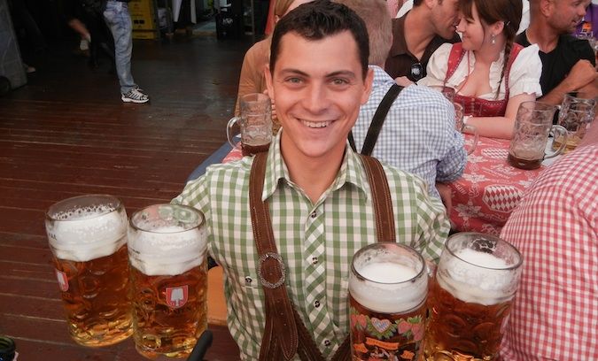 Matt Kepnes posing with 4 huge beers at Oktoberfest in Germany