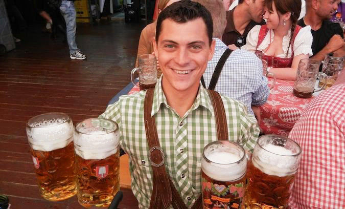 Nomadic Matt celebrating Oktoberfest in Germany with many beers