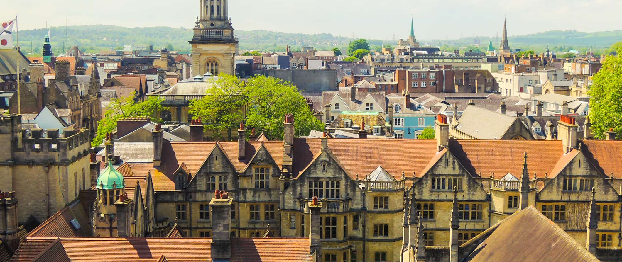 Quaint buildings in Oxford, UK on a sunny day with rolling hills in the distance