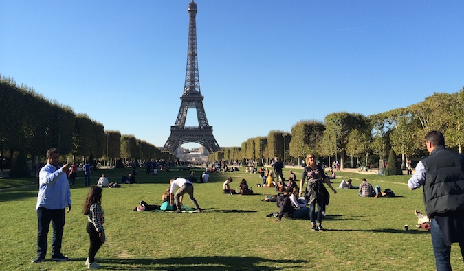 Tourists and locals relaxing in the grass near the Eiffel Tower in Paris