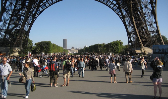 Tourists walking underneath the outside the Eiffel Tower in Paris