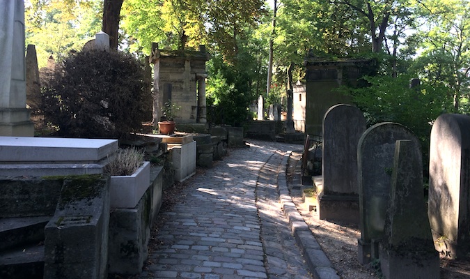 eerie photograph of the low-cal streaming on a crow at a cemetery Walking Among the Dead at Père Lachaise Cemetery