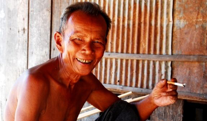 A local man smoking while posing for a photo in Asia