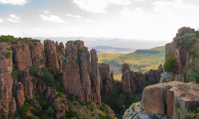 Tall rock formations in the hills of South Africa, leading to a sweeping valley