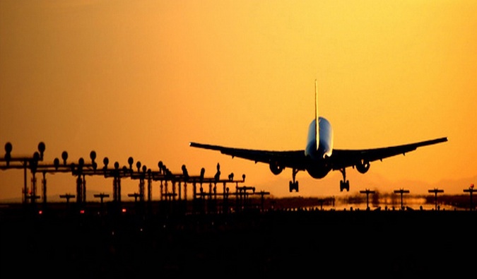 Un avion commercial décollant dans un coucher de soleil lumineux et doré.