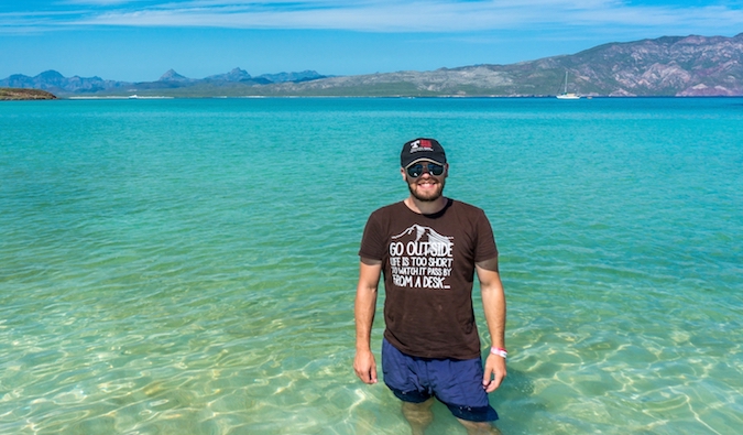 Ryan, an overlanding traveler, standing in the ocean