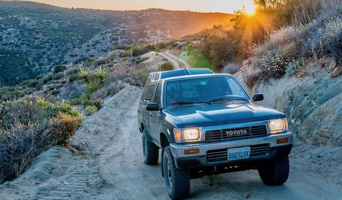 A truck driving over a steep and rocky mountain road