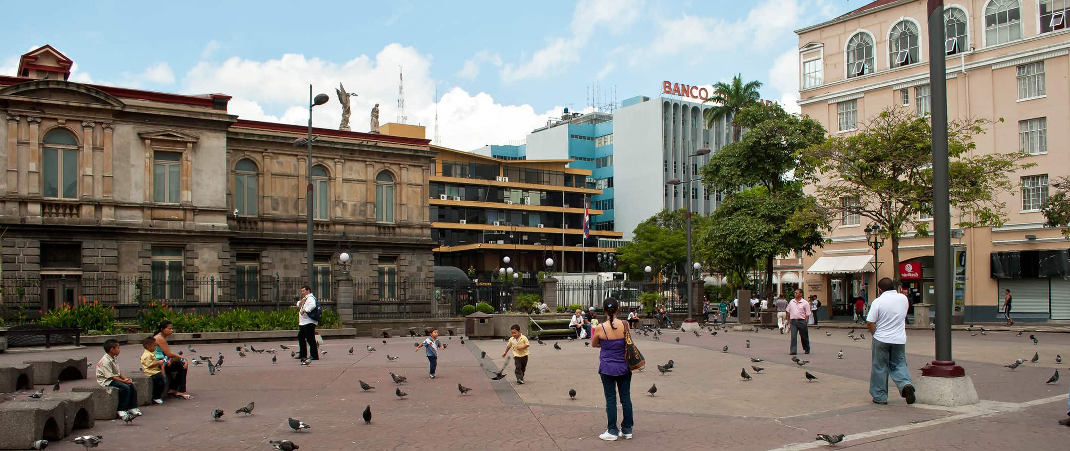 People walking around a central square filled with pigeons in San Jose, Costa Rica