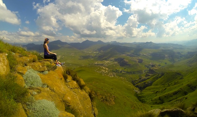 Kristin from be my travel muse sitting on a mountain ledge in South Africa thinking