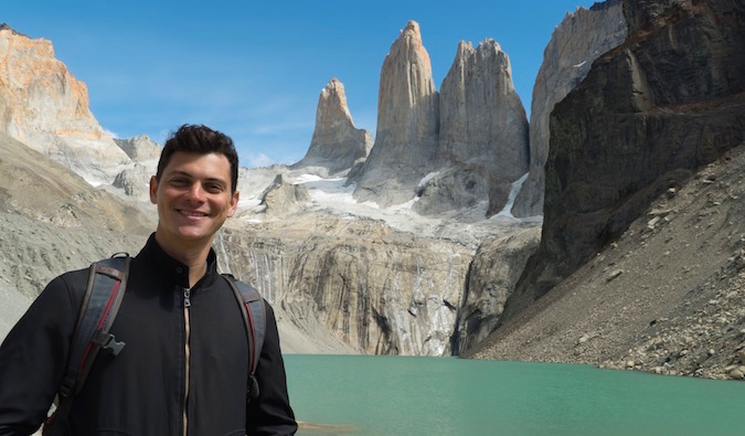 Nomadic Matt posing for a photo in Torres del Paine with towering mountains in the background