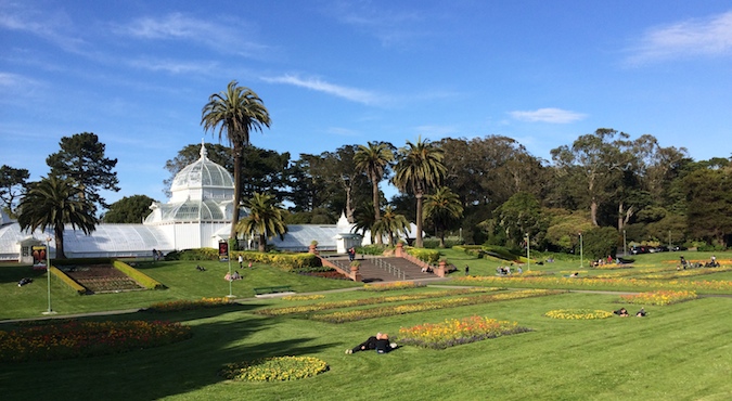 A beautiful photo of Golden Gate Park on a sunny day showing the lush greenery and white domed building