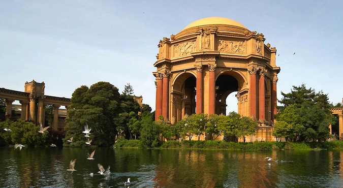 Gorgeous photo of dome surrounded by the water, shrubbery and birds at the Palace of Fine Arts taken during the golden hour