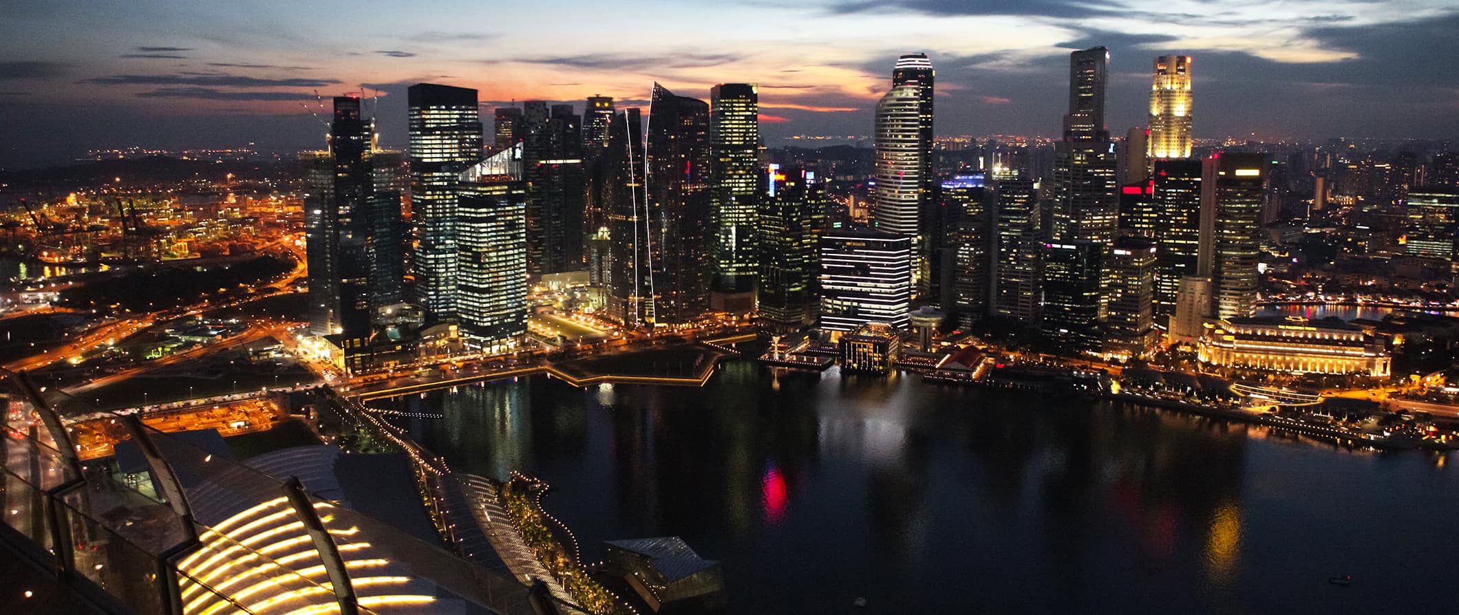 The skyline of urban Singapore, featuring skyscrapers all lit up at night