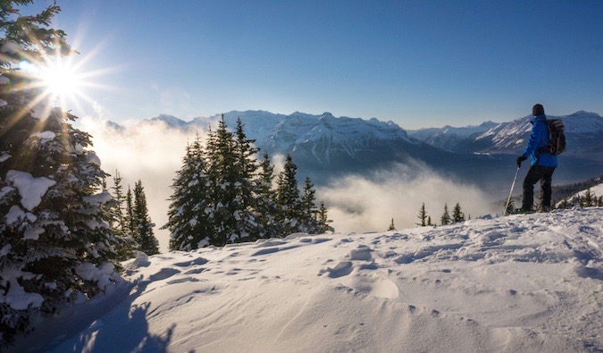 A solo female traveler hiking in the snowy mountains